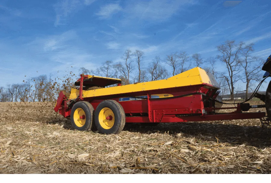 Representative New Holland box spreader working a harvested field