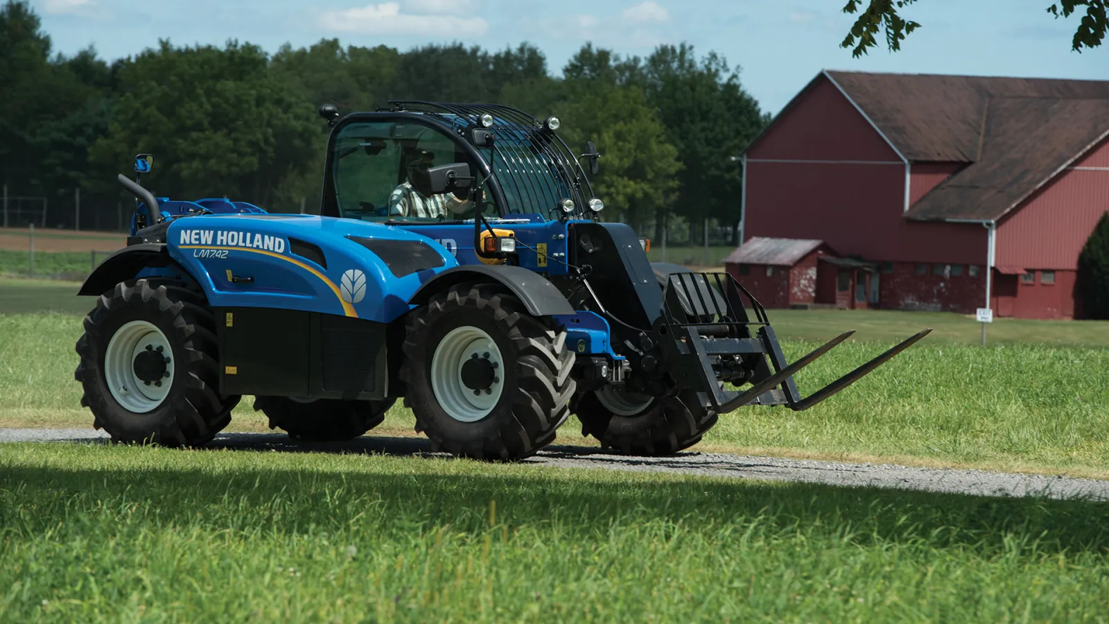Representative New Holland TH Series telehandler carrying a bale fork