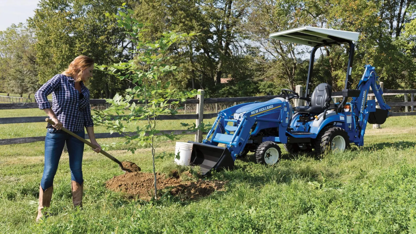 Representative New Holland WORKMASTER 25S tractor digging with a backhoe