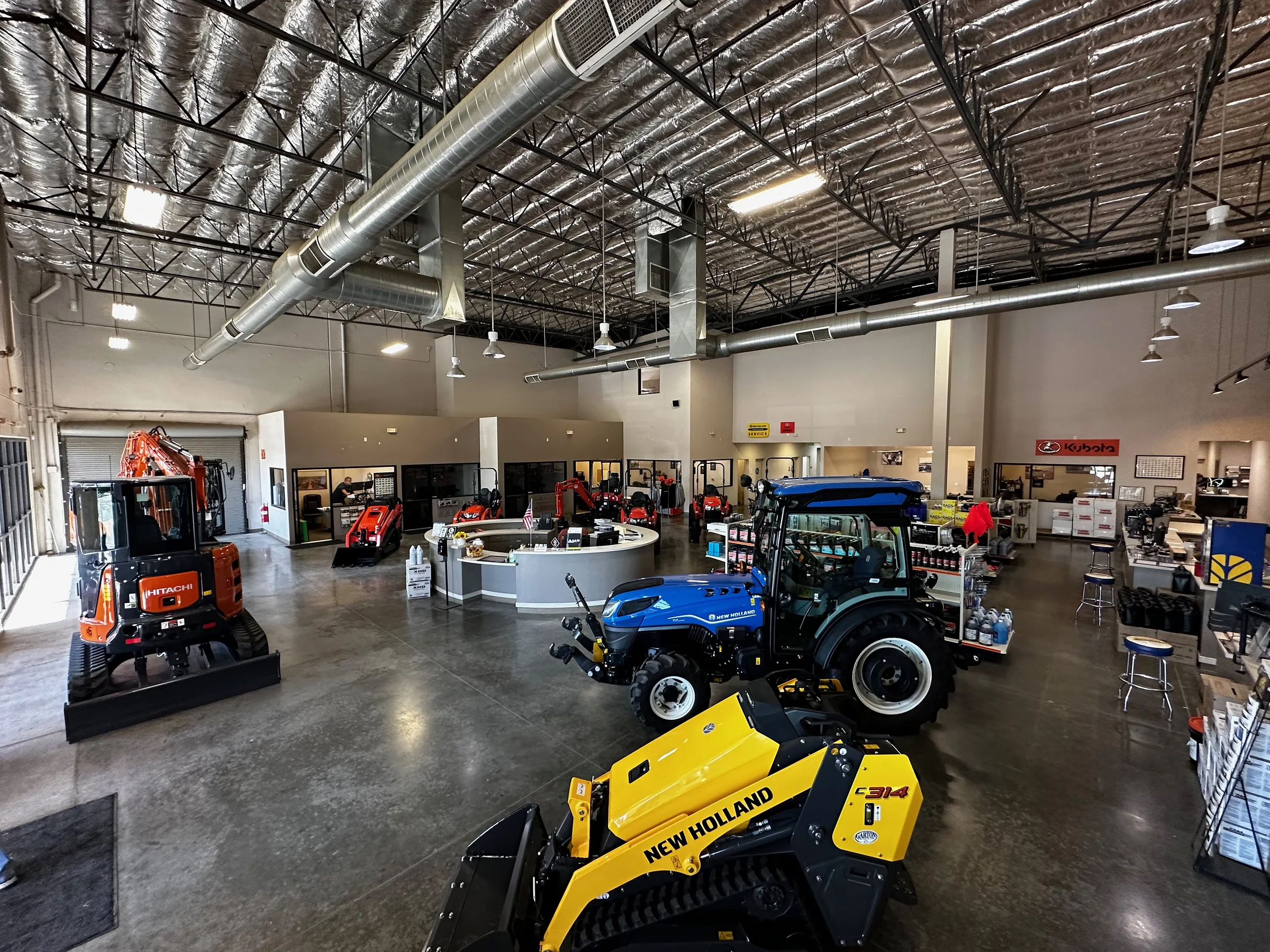 Garton Tractor showroom with Hitachi, Kubota, and New Holland equipment